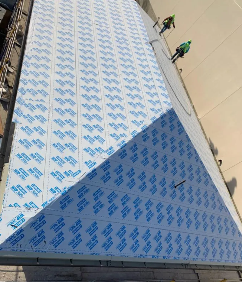 Professional roofers installing underlayment on a metal roof in Woodstock